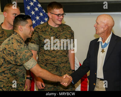 Us Marine Corps Ehrenmedaille Empfänger Oberst Robert J. Modrzejewski ret. spricht mit Gästen darüber, wie er die Ehrenmedaille an einem Zimmer feierstunde im Advanced Training Infanterie Bataillon, Schule der Infanterie West, Camp Pendleton, Calif, 14. Juli 2017 erhalten. Die Zeremonie fand statt, ein Klassenzimmer, jetzt in der Halle der Helden zu widmen, um die Ehrenmedaille Empfänger der Vergangenheit und Gegenwart. Colonel Robert J. Modrzejewski, eine Ehrenmedaille Empfänger, die von der Marine Corps im Jahr 1986 zurückzog, war die Zeremonie Ehrengast. (U.S. Marine Corps Foto von Pfc. Noah Rudash) Stockfoto