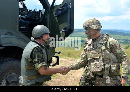 Us-Armee Generalmajor John Gronski, Stellvertretender Kommandierender General, Army National Guard, der U.S. Army Europe, spricht mit den Soldaten des 5.BATAILLON, 113 Field Artillery Regiment im Feld und mit rumänischen Militär Mitglieder in ihren Campingplatz. (U.S. Army National Guard Foto von Sgt. Odaliska Almonte, North Carolina National Guard Public Affairs/Freigegeben) Stockfoto