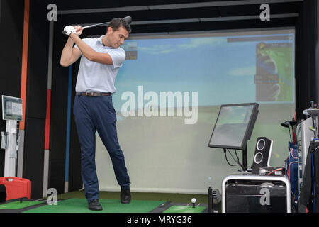 Man üben Golf Swing Simulator verwenden Stockfoto