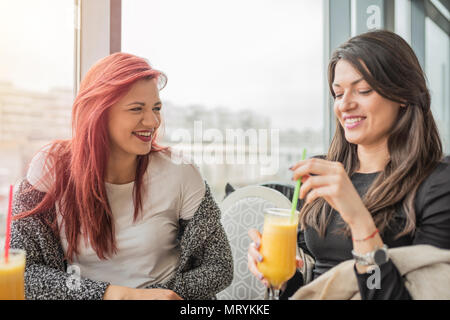 Porträt von zwei junge schöne Mädchen. Zwei junge weibliche Freunde zusammen in einem Restaurant genießen, lachen, reden, Tratschen. Stockfoto