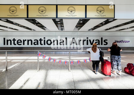 Menschen am Terminal 5 internationale Ankunftshalle, Flughafen Heathrow, London, Großbritannien warten Stockfoto