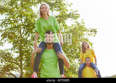 Junges Team macht piggyback Reiten in einem Workshop für Teambuilding Stockfoto
