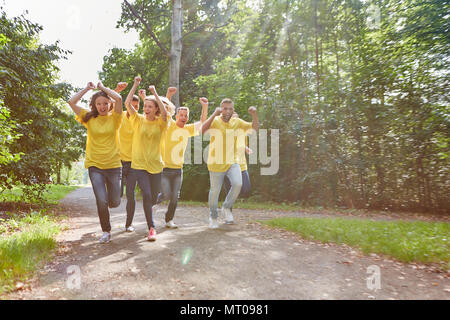 Glückliche Gewinner Team läuft Jubel im Park ein Teambuilding Event Stockfoto