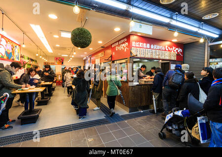 Indoor Omicho Ichiba, Omicho Markt mit frischen Lebensmitteln in Kanazawa, Japan. Leute anstellen an Oden one-Pot Restaurant während in der Sitzecke viele sitzen Essen Stockfoto