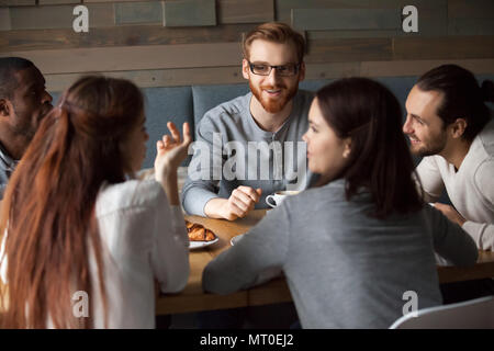 Diverse junge Leute unterhalten und Spaß zusammen im Cafe Stockfoto