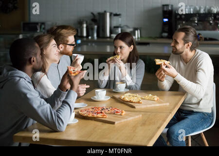 Lächelnd multirassischen Freunde sprechen trinken Kaffee essen Pizza Stockfoto