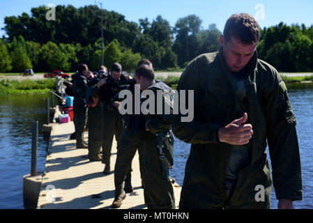 Staff Sgt. Joshua Krape, 4 Operations Support Squadron überleben, Steuerhinterziehung, Widerstand und Flucht Spezialist (rechts), Piloten, und Waffensysteme Offiziere von Seymour Johnson Air Force Base, Nord-Carolina, bereiten Sie ein Wasser überleben Training zu beginnen, 28. Juni 2017, in Buckhorn Reservoir, North Carolina. Piloten und des WSO sind verpflichtet, alle drei Jahre ihre WST und Combat survival Trainings zu Rezertifizieren. (U.S. Air Force Foto von Airman 1st Class Kenneth Boyton) Stockfoto