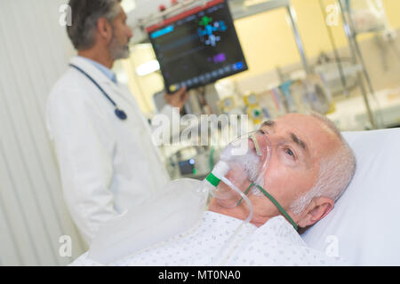Arzt prüft seine Patienten mit Sauerstoff Maske Stockfoto