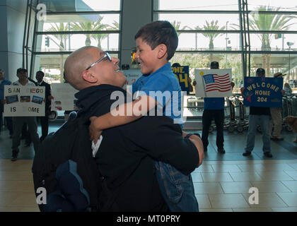 SAN DIEGO (16. April 2017) Chief Gunners Mate Adan Macias, zugeordnet zu den Littoral Combat Ship (LCS) Crew 204, umfaßt sein Sohn während ein homecoming Feier an der San Diego International Airport. LCS Crew 204 im Juni 2016 an Bord der USS Coronado bereitgestellt (LCS 4) für Maiden übersee Bereitstellung des Schiffes zur Unterstützung von Operationen mit regionalen Seestreitkräfte in der 7.Flotte Verantwortungsbereich. Stockfoto