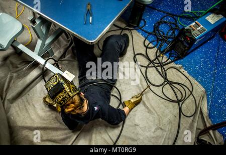 Die USS George H.W. Bush (CVN 77) ist ein nuklearer Flugzeugträger der Nimitz-Klasse der United States Navy, der 2009 in Betrieb genommen wurde. Das Archivbild dokumentiert einen Rüstungswartungstechniker, der Schweißarbeiten an den Meßdecks inspiziert, während das Schiff am 17. Juli 2017 im Mittelmeer operierte, mit der Trägerstreikgruppe im Zuständigkeitsbereich der 6. US-Flotte. Stockfoto