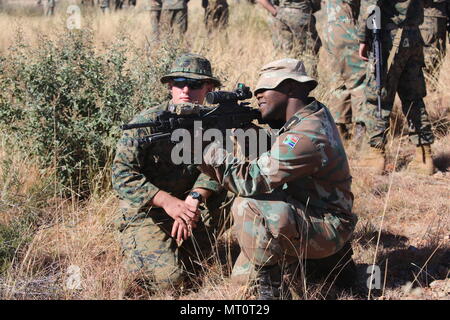 Us Marine LCpl. David B. Serge, beauftragt ein Mitglied der Südafrikanischen Marine Maritime Reaktion Squadron (Frau) auf die richtige Waffe Handhabung des US M 27 Infanterie automatisches Gewehr während einer Einarbeitung brand Bereich als Teil der Gemeinsamen Accord 17 (SA17) in der Südafrikanischen Armee Combat Training Center, Lohatla, Südafrika, 19. Juli 2017. Während SA 17 Mitglieder der Frau und US-Marineinfanteristen in integrierter Form Einheiten, Gebäude, Interoperabilität, wie sie erlernen die Techniken, Taktiken und Verfahren. SA 17 ist eine Gemeinsame bi- Bereich Training mit unseren südafrikanischen Partnern konzentrieren Stockfoto