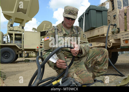 ​Indiana National Guard Pfc. Ronald Adams, von Warschau und eine Multichannel Übertragungssysteme Fahrer und Betreuer mit der Firma C, Feuerwehr 776th Engineer Battalion, verbindet die Alternative aktuelle Netzkabel von einem Humvee mit einem Generator in Fort Polk, Louisiana, Mittwoch, 19. Juli 2017. Adams ist eine von rund 6.100 Service Mitglieder die Teilnahme an oder die Unterstützung bei der 76th Infantry Brigade Combat Team das 12-tägige Schulung Schlacht an der Louisiana post. Foto von Master Sgt. Jeff Lowry, 38th Infantry Division Public Affairs Stockfoto