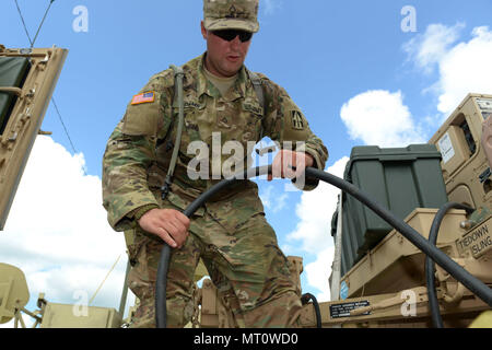 ​Indiana National Guard Pfc. Ronald Adams, von Warschau und eine Multichannel Übertragungssysteme Fahrer und Betreuer mit der Firma C, Feuerwehr 776th Engineer Battalion, verbindet die Alternative aktuelle Netzkabel von einem Humvee mit einem Generator in Fort Polk, Louisiana, Mittwoch, 19. Juli 2017. Adams ist eine von rund 6.100 Service Mitglieder die Teilnahme an oder die Unterstützung bei der 76th Infantry Brigade Combat Team das 12-tägige Schulung Schlacht an der Louisiana post. Foto von Master Sgt. Jeff Lowry, 38th Infantry Division Public Affairs Stockfoto