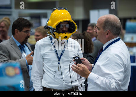 170720-N-PO 203-686 WASHINGTON (Jan. 20, 2017) Dennis Gallagher, ein Ingenieur von der Naval Surface Warfare Center, Panama City, erklärt die Taucher Augmented Vision Display (DVAD) um einen Teilnehmer während der Amtszeit des Naval Research Naval Zukunft Kraft von Wissenschaft und Technologie (W&T) Expo am Walter E. Washington Convention Center. Die DAVD ist ein hochauflösendes, sehen - durch Heads-up-Display (HUD) direkt im Inneren eines tauchen Helm, mit der Taucher eine visuelle Anzeige der alles von Sektor Sonar, Text, Grafiken, Fotos und sogar Video zur erweiterten Realität eingebettet Stockfoto