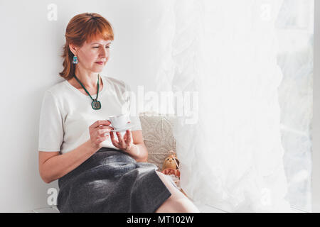 Portrait von lächelnden reife Frau. Ältere Frau, die an der Wand Stockfoto