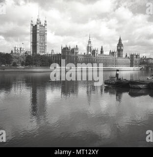 1950er Jahre, historisch, Blick vom Süden des Flusses über die Themse, London, zu den ikonischen Gebäuden des Palace of Westminster, Treffpunkt der britischen Regierung. Am Palast befinden sich die beiden Häuser des britischen Parlaments, das Unterhaus und das Oberhaus. Stockfoto