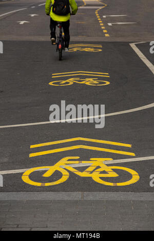 Gelbe Zeichen für einen Radweg auf der Asphaltstraße gezeichnet. Wege für Radfahrer. Radfahrer auf städtischen cycleway. Verkehrszeichen und die Sicherheit im Straßenverkehr. Stockfoto