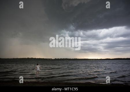 Ein kleines Mädchen erscheinen bei einem Sturm über dem Wasser zu schweben. Stockfoto