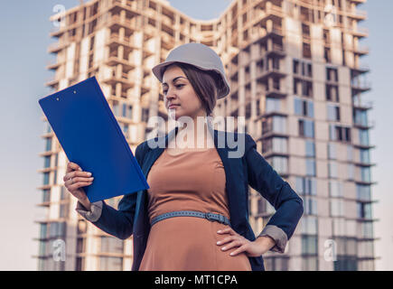 Wunderschöne Business woman Ingenieur steht mit plan Papiere. Stockfoto