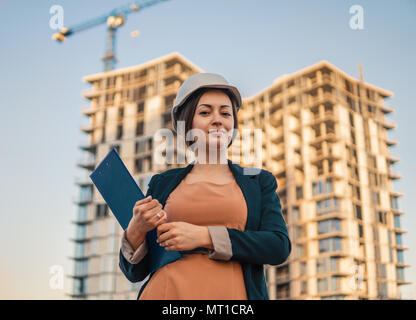 Wunderschöne Business woman Ingenieur steht mit plan Papiere. Stockfoto