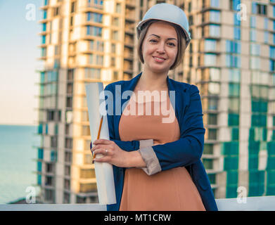 Wunderschöne Business woman Ingenieur steht mit plan Papiere. Stockfoto
