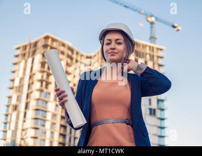 Wunderschöne Business woman Ingenieur steht mit plan Papiere. Stockfoto