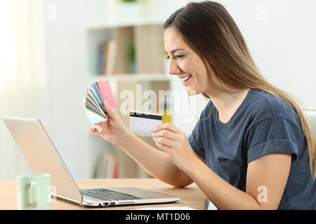 Happy shopper online kaufen mit mehreren Kreditkarten und ein Laptop zu Hause Stockfoto