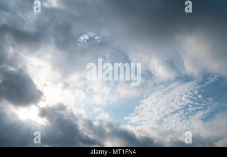 Sonne strahlen durch Gewitterwolken mit blauer Himmel Dahinter Stockfoto