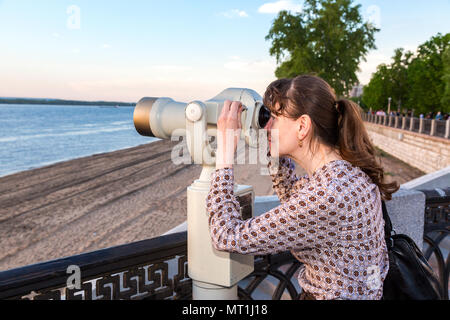 Samara, Russland - 19 Mai, 2018: die junge Frau auf der Suche durch die Münze Fernglas am Ufer des Flusses Wolga im Sommer betrieben Stockfoto