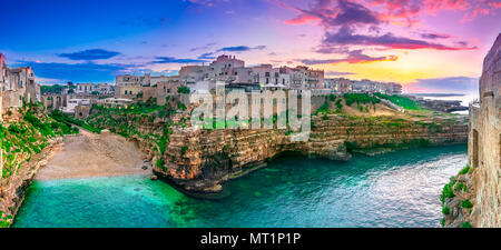 Polignano a Mare, Apulien, Italien: Sonnenuntergang in Cala Paura Golf mit Bastione di Santo Stefano und Lama Monachile Strand Stockfoto