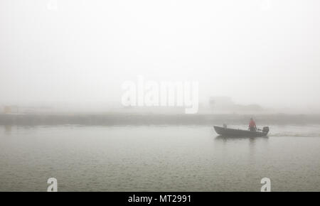 Kajakfahrer und Sportboote in Port Stanley Hafen unter einer Decke von dichtem Nebel. Stockfoto