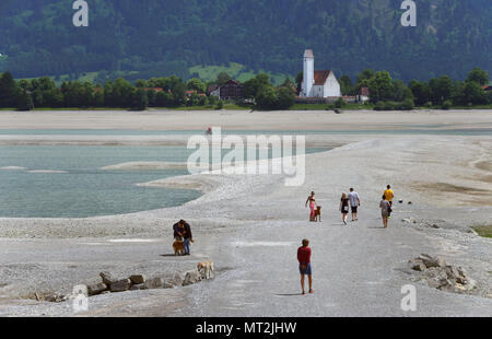 27. Mai 2018, Deutschland, Schwangau: Menschen gehen in der baisin der trockenen Forggensee mit der Kirche von Waltenhofen im Hintergrund. Deutschlands größte Reservoir kann derzeit nicht aufgestaut, wegen Wartungsarbeiten auf dem Damm. Foto: Karl-Josef Hildenbrand/dpa Stockfoto