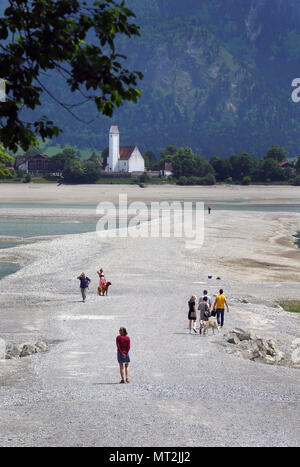 27. Mai 2018, Deutschland, Schwangau: Menschen gehen in der baisin der trockenen Forggensee mit der Kirche von Waltenhofen im Hintergrund. Deutschlands größte Reservoir kann derzeit nicht aufgestaut, wegen Wartungsarbeiten auf dem Damm. Foto: Karl-Josef Hildenbrand/dpa Stockfoto