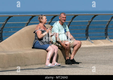Frau Schattierung, um sich von der Sonne in Blackpool, Lancashire. UK Wetter. 28 Mai, 2018. Hellen sonnigen Start in den Tag an der Küste wie Urlaubern und Touristen die Annehmlichkeiten und Attraktionen an der Strandpromenade genießen. im warmen Sonnenschein. Credit: MediaWorldImages/AlamyLiveNews Stockfoto