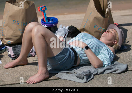 Primark shopper Sonnenbaden an Blackpool, Lancashire. UK Wetter. 28 Mai, 2018. Hellen sonnigen Start in den Tag an der Küste wie Urlaubern und Touristen die Annehmlichkeiten und Attraktionen an der Strandpromenade genießen. im warmen Sonnenschein. Credit: MediaWorldImages/AlamyLiveNews Stockfoto