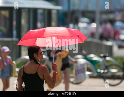Frau Schattierung, um sich von der Sonne in Blackpool, Lancashire. UK Wetter. 28 Mai, 2018. Hellen sonnigen Start in den Tag an der Küste wie Urlaubern und Touristen die Annehmlichkeiten und Attraktionen an der Strandpromenade genießen. im warmen Sonnenschein. Credit: MediaWorldImages/AlamyLiveNews Stockfoto