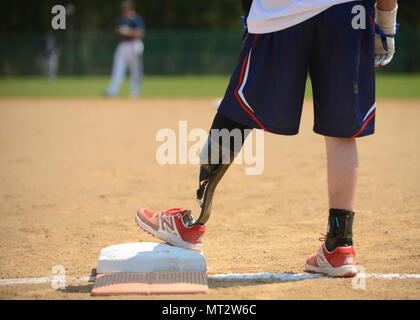 Ein verwundeter Krieger Amputee Softball Team steht an der ersten Base während der WWAST Spiel gegen die Newport News Polizei und Feuerwehr in Newport News, Virginia, 15. April 2017. Amputationen der Mitglieder reichen von oberhalb des Knies unter den Ellenbogen, und sie hoffen, zu erziehen, andere, die "das Leben ohne Gliedmaßen grenzenlos ist." Stockfoto