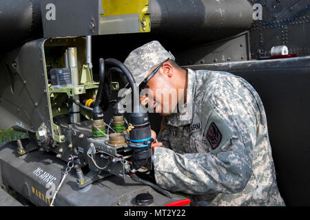 Spc. Kourtland Slater, mit 1St Bataillon, 130 Luftfahrt, North Carolina Army National Guard, passt die Waffen Auswurf kostenlos auf einem AH-64D Apache Kampfhubschrauber am Joint Readiness Training Center, Fort Polk, Louisiana, 22. Juli 2017. Foto von Sgt. 1. Klasse David Bruce, 38th Infantry Division Public Affairs Stockfoto