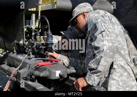 Spc. Kourtland Slater und Sgt. Robert Ricks, mit 1St Bataillon, 130 Luftfahrt, North Carolina Army National Guard, passt die Waffen Auswurf kostenlos auf einem AH-64D Apache Kampfhubschrauber am Joint Readiness Training Center, Fort Polk, Louisiana, 22. Juli 2017. Foto von Sgt. 1. Klasse David Bruce, 38th Infantry Division Public Affairs Stockfoto