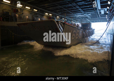 170724-N-ZL 062-038 CORAL SEA (24 Juli 2017) Landing Craft utility 1666, zu Naval Beach Einheit 7 zugeordnet, betritt die gut Deck des amphibious Transport dock USS Green Bay LPD (20) Marine Equipment in Talisman Sabre 17 zu verlagern. Talisman Säbel ist eine Biennale USA - Australien bilaterale Übung gehalten weg von der Küste von Australien gedacht, um die Interoperabilität zu erreichen und den USA - Australien Bündnis stärken. (U.S. Marine Foto von Mass Communication Specialist 3. Klasse Sarah Myers/Freigegeben) Stockfoto