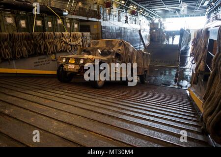 170724-N-ZL 062-065 CORAL SEA (Juli 24, 2017) ein Marine Fahrzeug disembarks Landing Craft utility 1666 in der gut Deck des amphibious Transport dock USS Green Bay LPD (20) Nach der Talisman Sabre 17. Talisman Säbel ist eine Biennale USA - Australien bilaterale Übung gehalten weg von der Küste von Australien gedacht, um die Interoperabilität zu erreichen und den USA - Australien Bündnis stärken. (U.S. Marine Foto von Mass Communication Specialist 3. Klasse Sarah Myers/Freigegeben) Stockfoto