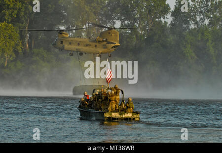 Aktive Armee Soldaten aus der 502Nd Multi Role Brücke Co., warten Sie, bis die innere Brücke bucht Abschnitte von CH-47 Chinook Hubschrauber abgesetzt zu werden, bevor Sie die Bühne und zusammen. Us-Armee, Aktive und Reservisten melden Sie mit Aktiven und finden Marine Komponenten bereitzustellen, zu konstruieren und eine rund 320 meter schwimmende Verbesserte ribbon Brücke über den Arkansas River bei River Assault 2017 montieren, am Fort Chaffee Manöver Zentrum, Arche, 26. Juli 2017. River Assault 2017 ist ein 2-Woche verlängert Kampftraining Ausübung gehalten Juli 15-28 mit Schwerpunkt auf den technischen Fähigkeiten, der verschiedenen Serv Stockfoto