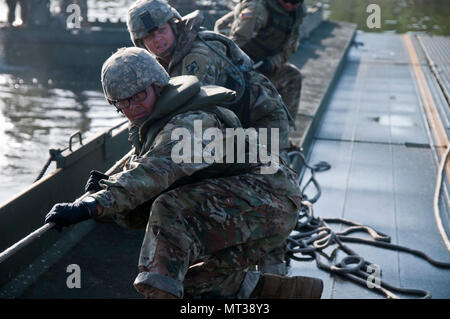 Aktive Armee Soldaten aus der 502Nd Multi Role Brücke Co., Ziehen am Seil Innenraum bridge Bay, zusammen zu bringen. Us-Armee, Aktive und Reservisten melden Sie mit Aktiven und finden Marine Komponenten bereitzustellen, zu konstruieren und eine rund 320 meter schwimmende Verbesserte ribbon Brücke über den Arkansas River bei River Assault 2017 montieren, am Fort Chaffee Manöver Zentrum, Arche, 26. Juli 2017. River Assault 2017 ist ein 2-Woche verlängert Kampftraining Ausübung gehalten Juli 15-28 mit Schwerpunkt auf den technischen Fähigkeiten, von verschiedenen Service für Mitglieder, die ihren Höhepunkt mit dem Bau eines schwimmenden Impr Stockfoto