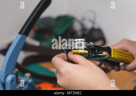 Skinner macht Löcher in Leder Stück. Arbeiten in der Werkstatt. Stockfoto