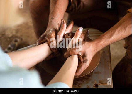 Closeup Hand der Potter und seine jungen Lehrling eine Vase auf einem sich drehenden Töpferscheibe erstellen Stockfoto