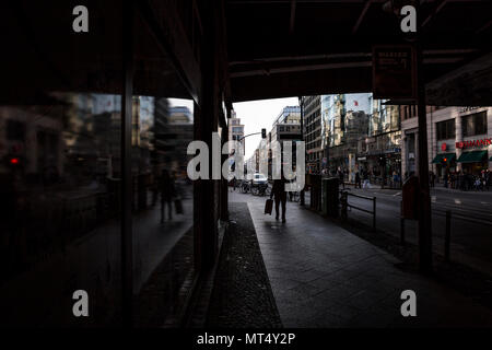 Ein shopper Spaziergänge unter einer Brücke an der Friedrichstraße in Berlin, Deutschland. Stockfoto