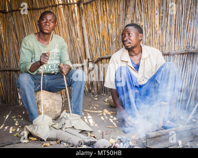 Luzibalule, Namibia - August 13, 2015: Zwei nicht identifizierte die afrikanischen Männer die traditionelle an Lizauli Traditional Village Forge Stockfoto