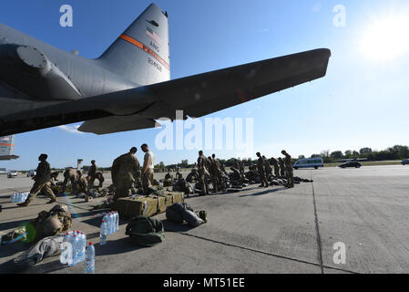 Militärangehörige aus mehreren Nationen versammeln sich am 21. Juli 2017 in der Nähe eines C-130-Herkules-Flugzeugs auf der Papa Air Base, Ungarn, um sich auf die Luftangriffe während der Übung Swift Response 17 vorzubereiten. Das archivierte Fotoarchiv dokumentiert multinationale Koordination und Vorbereitung vor dem Sprung als Teil von Saber Guardian 17. Stockfoto