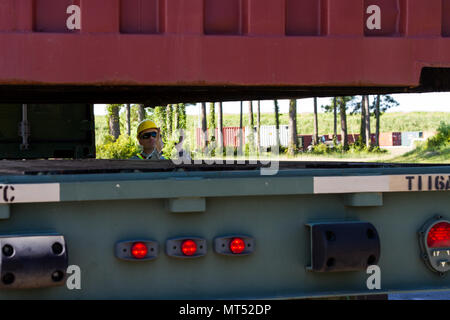Der Mi-Jack Railstacker ist ein gummiarmes Portalkran-System für den intermodalen Containerumschlag in Schienen- und Hafenumgebungen. Während der Operation Trans Mariner 17 am Military Ocean Terminal Sunny Point, North Carolina, wurde am 30. Juli 2017 Frachtcontainer auf einen 5-Tonnen-6x6-Lkw M-878 geladen. Das Archivbild dokumentiert den koordinierten Transport von Fracht innerhalb der Logistikoperationen der Army Reserve. Stockfoto