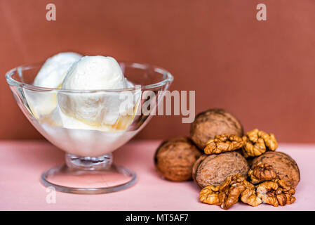 Vanilleeis in der Schüssel und Walnüsse Stockfoto